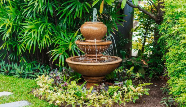 Taman dengan perpaduan tanaman hijau dan hiasan air mancur